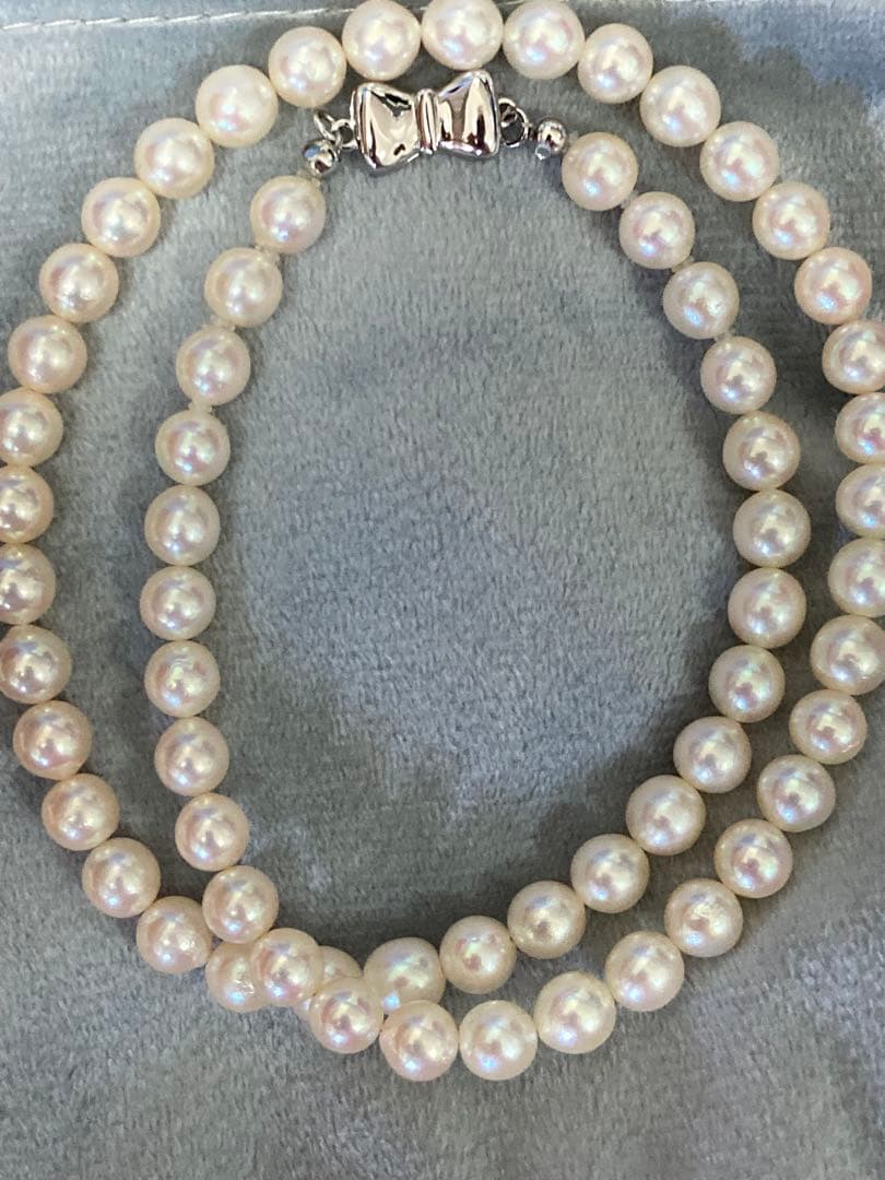 Oyster Akoya pearl necklace with 6-6.5mm pearls and silver clasp laid flat on white background
