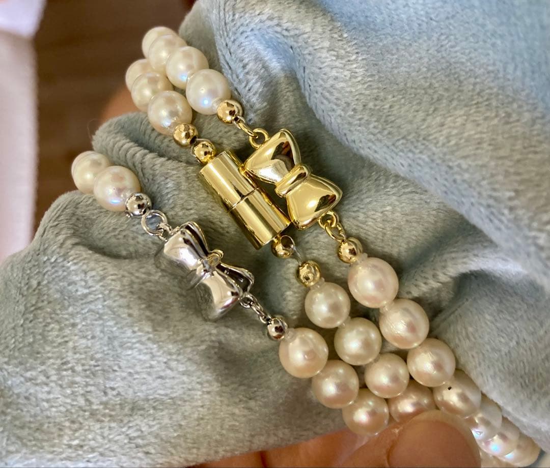 Oyster Akoya pearl necklace with 6-6.5mm pearls and silver clasp laid flat on white background