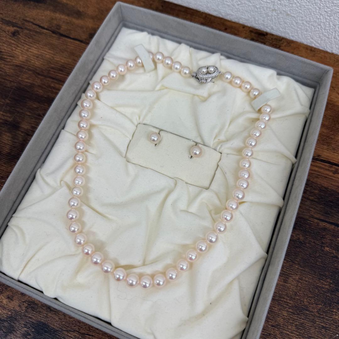 Tasaki pearl necklace and matching earrings displayed with the included case