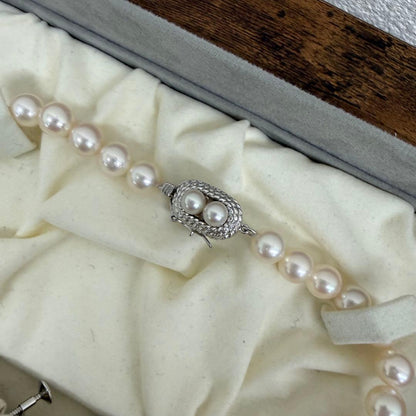 Tasaki pearl necklace and matching earrings displayed with the included case