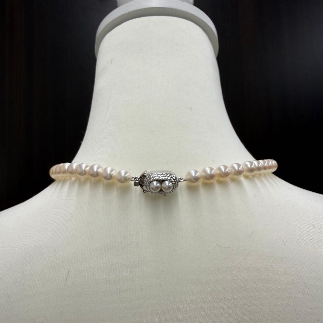 Tasaki pearl necklace and matching earrings displayed with the included case