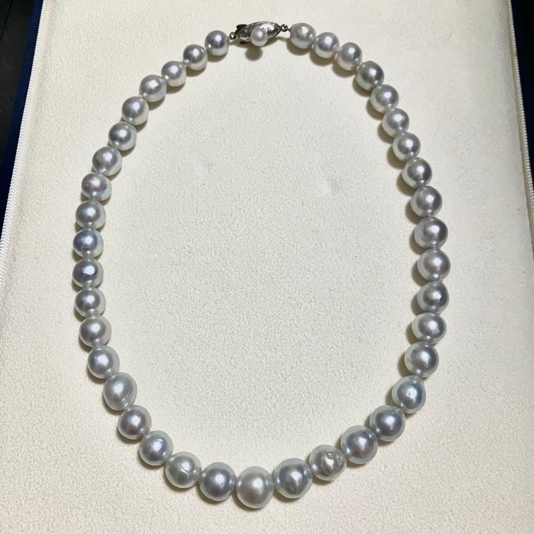Akoya pearl necklace with 9.0mm pearls laid out showing clasp and identification book