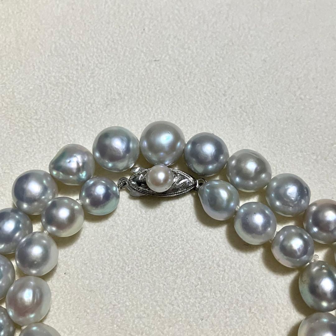 Akoya pearl necklace with 9.0mm pearls laid out showing clasp and identification book