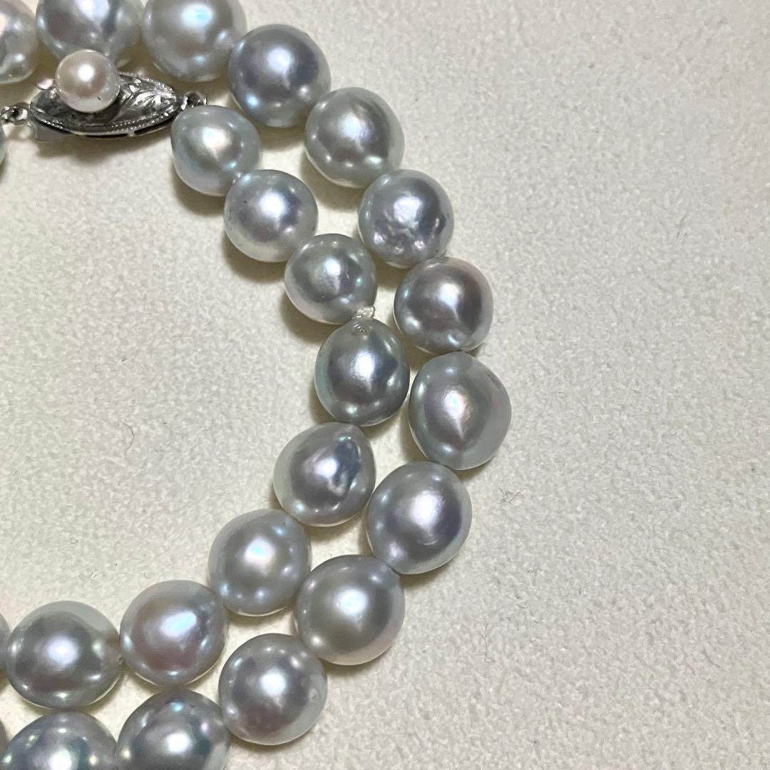 Akoya pearl necklace with 9.0mm pearls laid out showing clasp and identification book