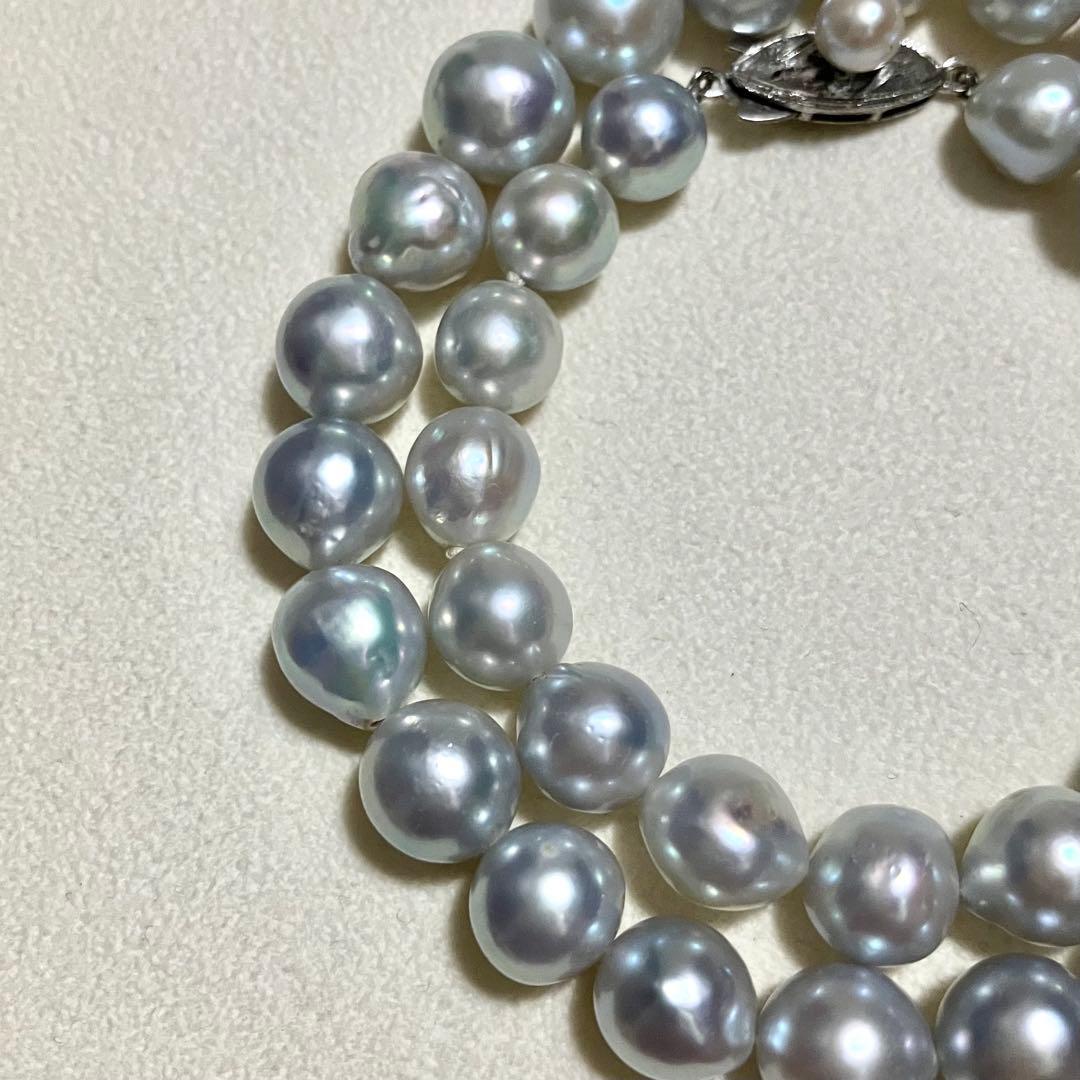 Akoya pearl necklace with 9.0mm pearls laid out showing clasp and identification book