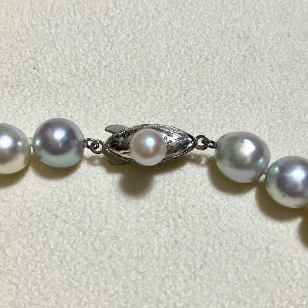 Akoya pearl necklace with 9.0mm pearls laid out showing clasp and identification book