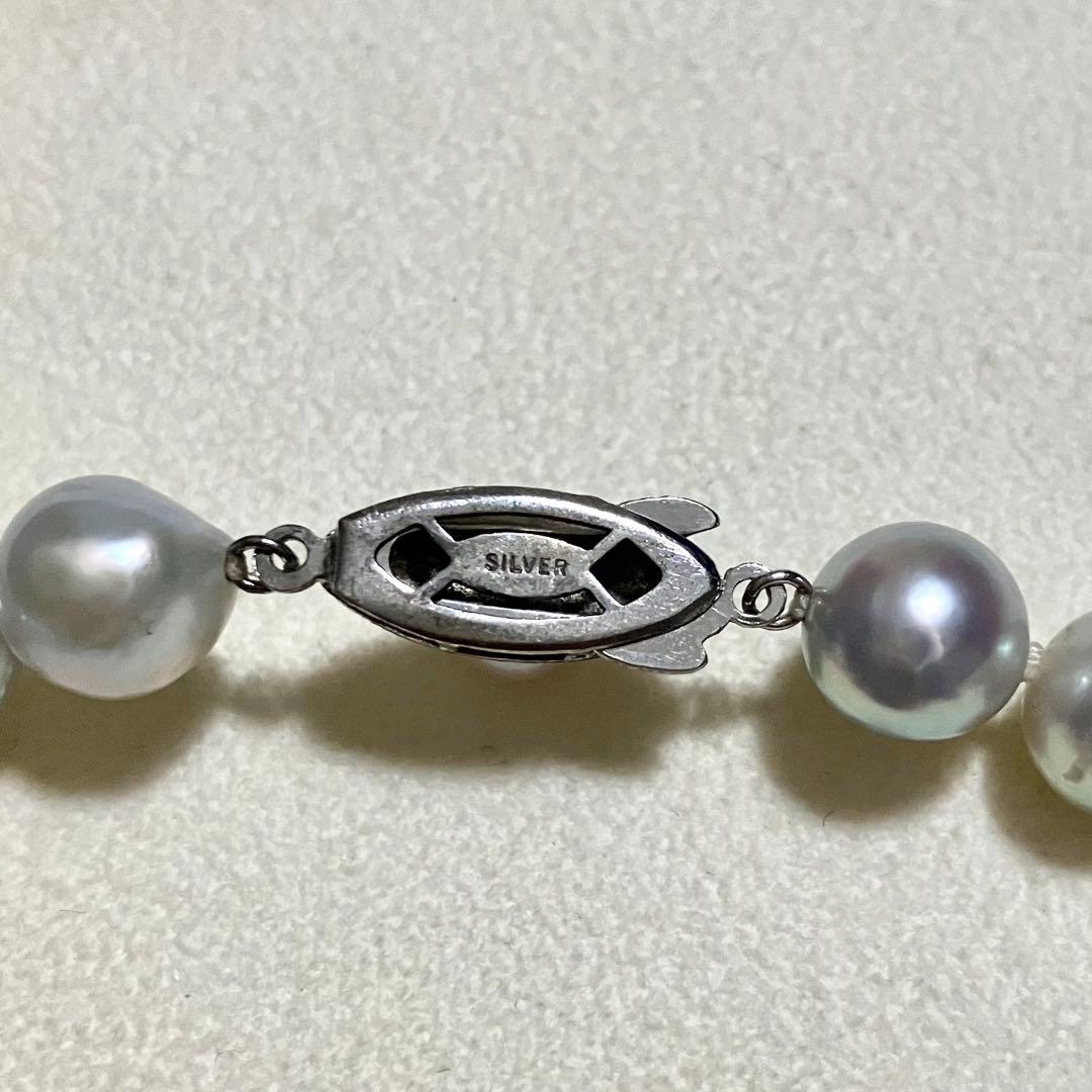 Akoya pearl necklace with 9.0mm pearls laid out showing clasp and identification book