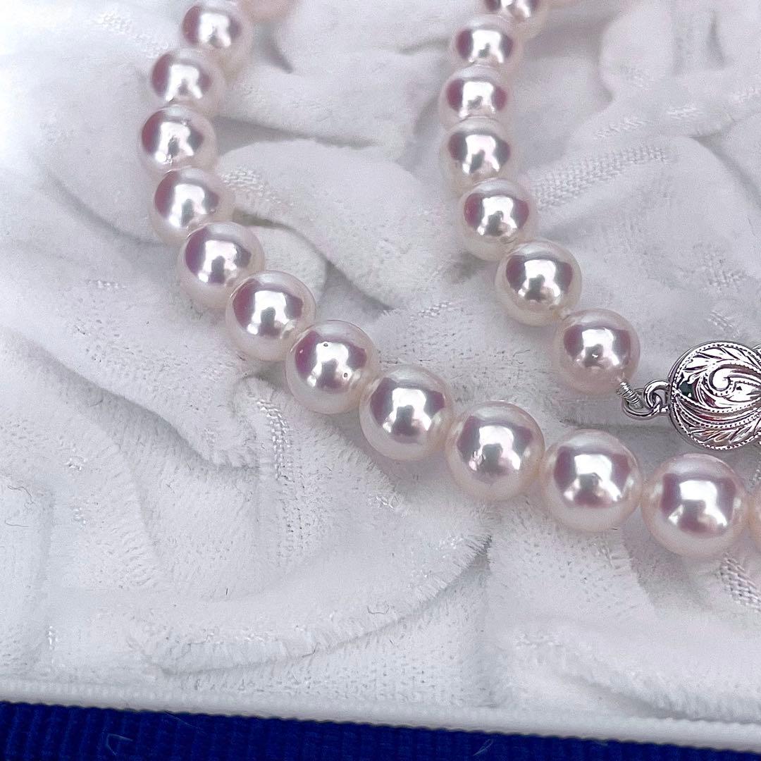 Mikimoto Akoya pearl necklace with 6.5-7mm white pink pearls, M charm, and silver current clasp on a white background