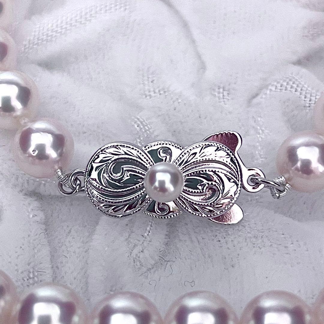 Mikimoto Akoya pearl necklace with 6.5-7mm white pink pearls, M charm, and silver current clasp on a white background