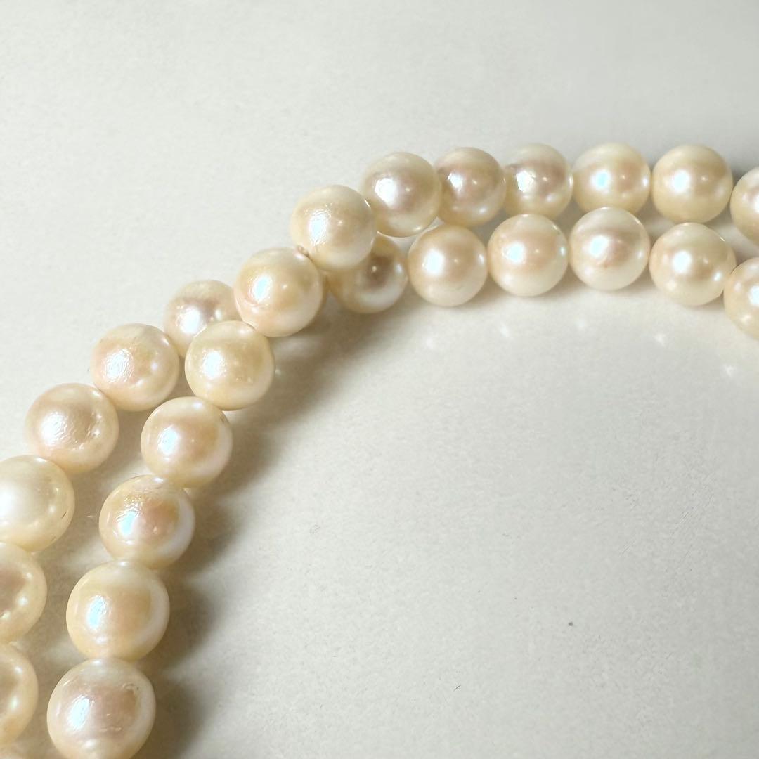 Okoya pearl necklace with pink pearls and silver clasp on white background