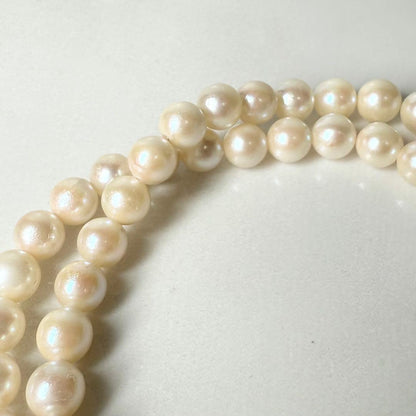 Okoya pearl necklace with pink pearls and silver clasp on white background