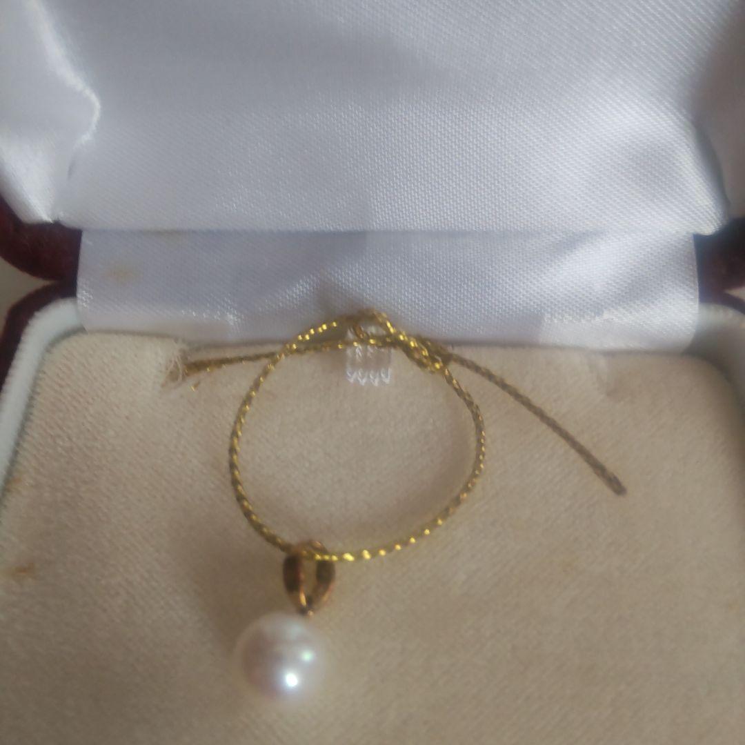 Pearl and gold pendant necklace with elegant pearl design on a white background in dedicated case