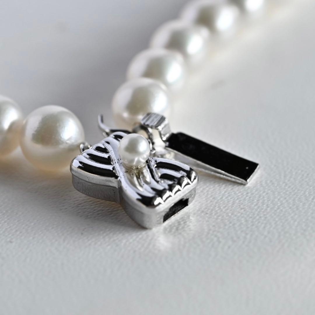 Takatsuki Akoya pearl necklace with 7.5mm round pearls and silver ribbon clasp on a white background
