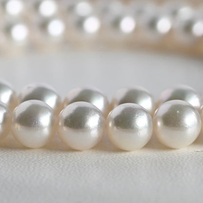 Takatsuki Akoya pearl necklace with 7.5mm round pearls and silver ribbon clasp on a white background
