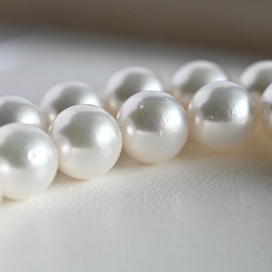 Takatsuki Akoya pearl necklace with 7.5mm round pearls and silver ribbon clasp on a white background