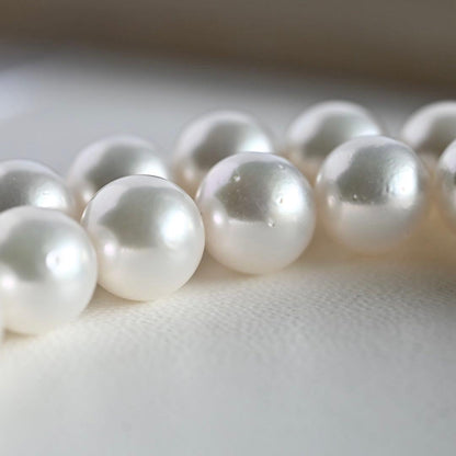 Takatsuki Akoya pearl necklace with 7.5mm round pearls and silver ribbon clasp on a white background