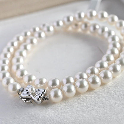 Takatsuki Akoya pearl necklace with 7.5mm round pearls and silver ribbon clasp on a white background