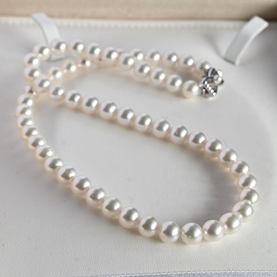 Takatsuki Akoya pearl necklace with 7.5mm round pearls and silver ribbon clasp on a white background