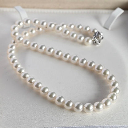 Takatsuki Akoya pearl necklace with 7.5mm round pearls and silver ribbon clasp on a white background