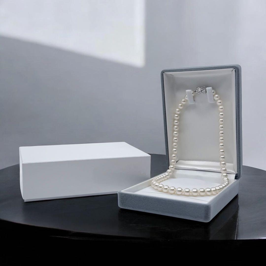Takatsuki Akoya pearl necklace with 7.5mm round pearls and silver ribbon clasp on a white background
