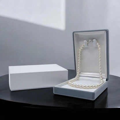 Takatsuki Akoya pearl necklace with 7.5mm round pearls and silver ribbon clasp on a white background