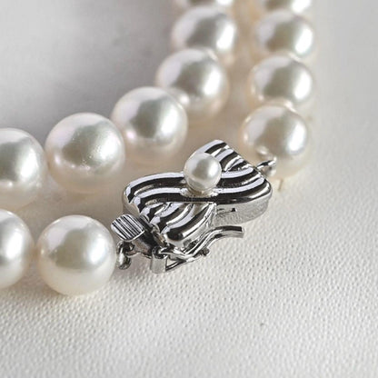 Takatsuki Akoya pearl necklace with 7.5mm round pearls and silver ribbon clasp on a white background