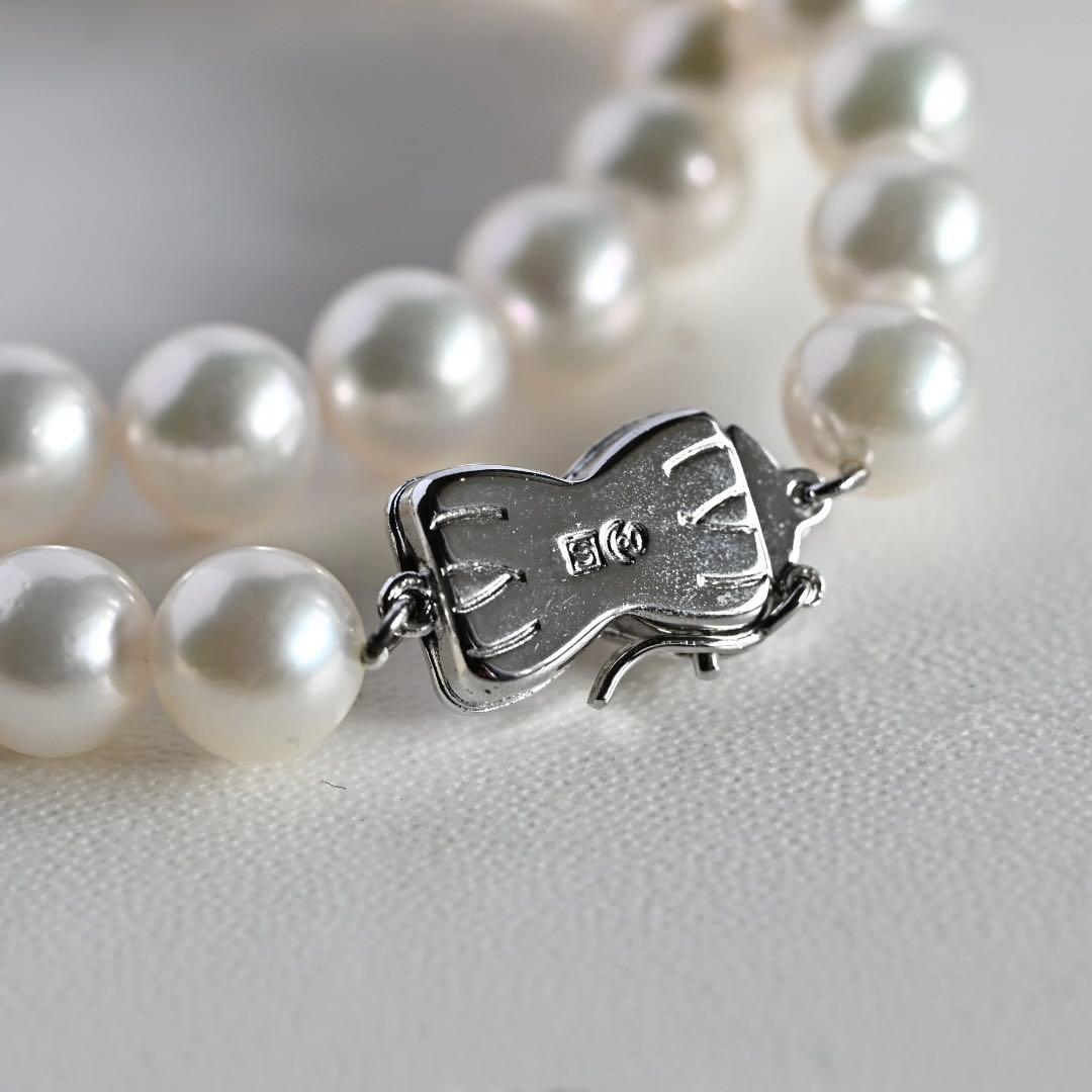 Takatsuki Akoya pearl necklace with 7.5mm round pearls and silver ribbon clasp on a white background
