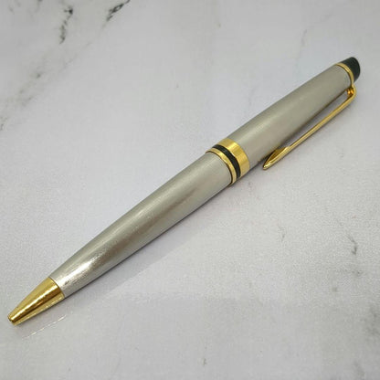 Waterman Expert ballpoint pen with steel satin finish and 23K gold trim, showing minor wear