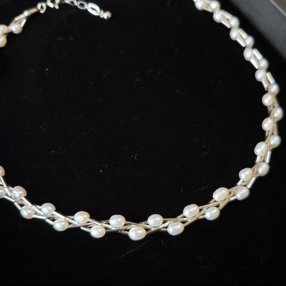 Elegant white Mikimoto Pearl Island pearl necklace with metal accents and adjustable clasp shown in dedicated box