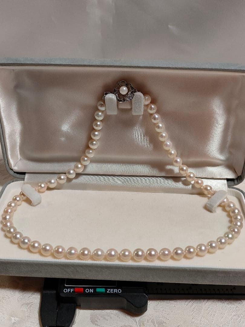 Akoya pearl necklace with white pearls 6.5-6.9 mm and silver push-insertion clasp on white background