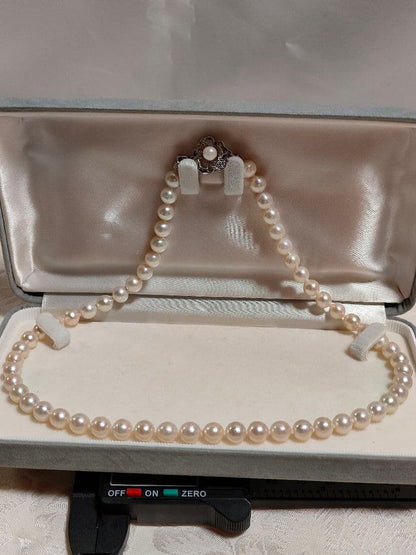 Akoya pearl necklace with white pearls 6.5-6.9 mm and silver push-insertion clasp on white background