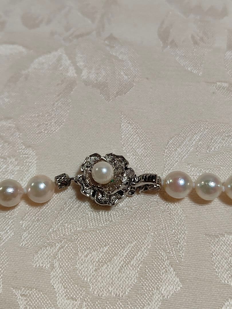 Akoya pearl necklace with white pearls 6.5-6.9 mm and silver push-insertion clasp on white background