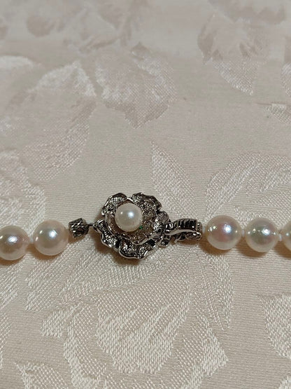 Akoya pearl necklace with white pearls 6.5-6.9 mm and silver push-insertion clasp on white background