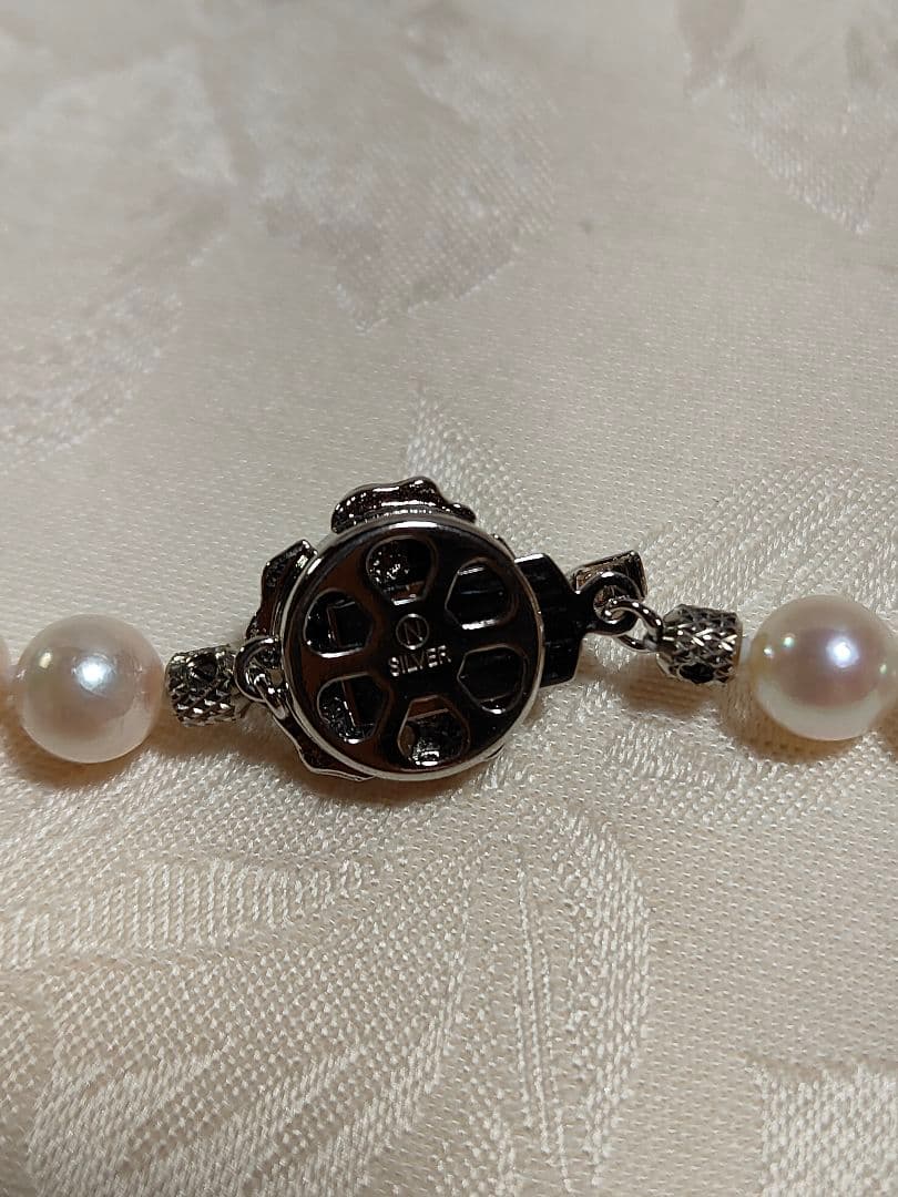 Akoya pearl necklace with white pearls 6.5-6.9 mm and silver push-insertion clasp on white background