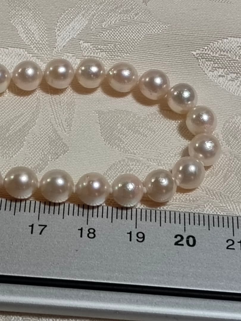 Akoya pearl necklace with white pearls 6.5-6.9 mm and silver push-insertion clasp on white background