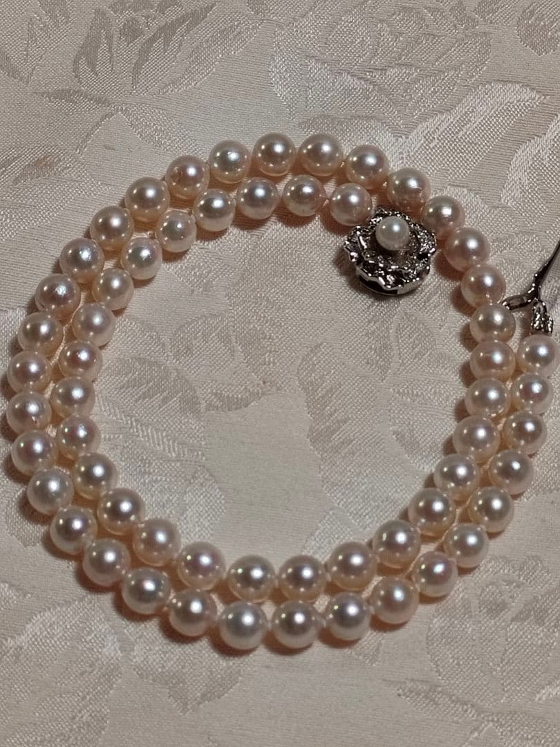 Akoya pearl necklace with white pearls 6.5-6.9 mm and silver push-insertion clasp on white background