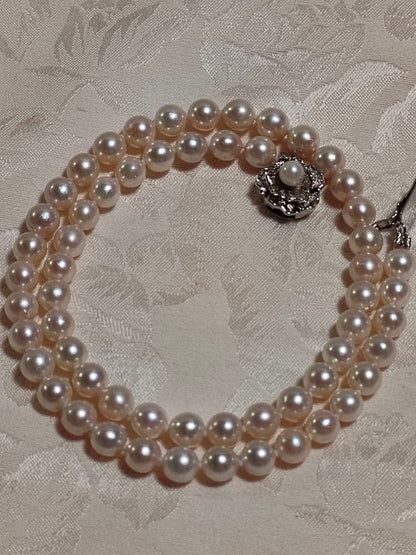 Akoya pearl necklace with white pearls 6.5-6.9 mm and silver push-insertion clasp on white background