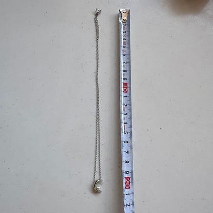 Tasaki Baby Pearl and Moon Necklace featuring silver moon pendant and lustrous pearls