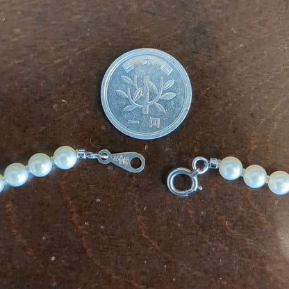 Vintage Pt850 Akoya pearl necklace with 5mm pearls and mint mark clasp on a white background