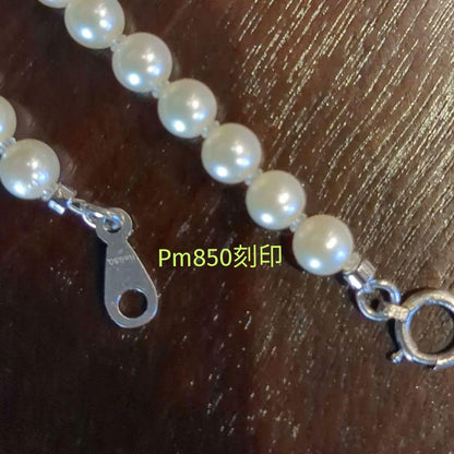 Vintage Pt850 Akoya pearl necklace with 5mm pearls and mint mark clasp on a white background