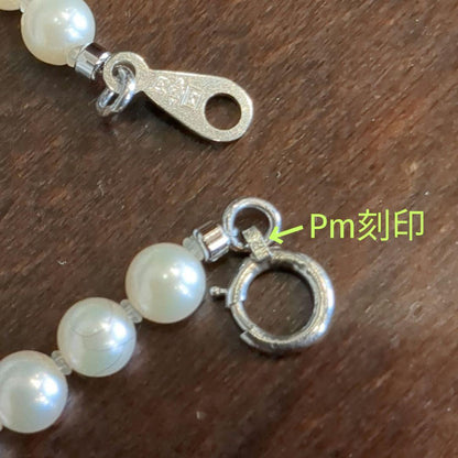 Vintage Pt850 Akoya pearl necklace with 5mm pearls and mint mark clasp on a white background
