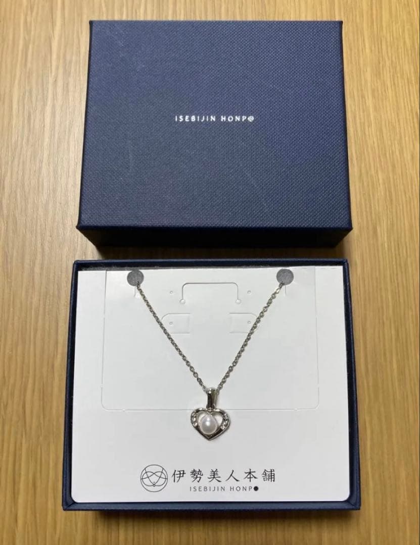 Heart-shaped silver necklace with white Akoya pearls on a white background