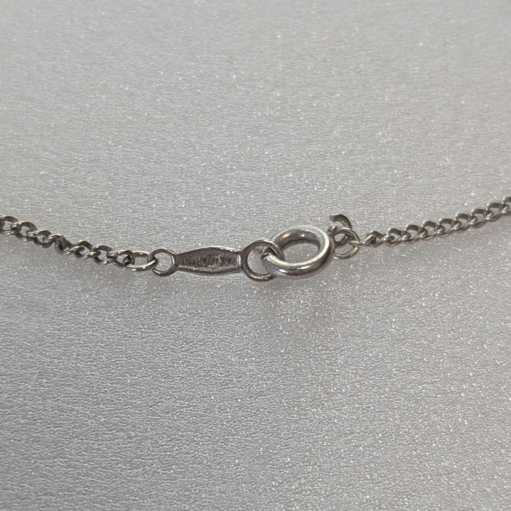 Mikimoto necklace with silver diamond-shaped pendant and glossy white pearl hanging on a 42cm silver chain
