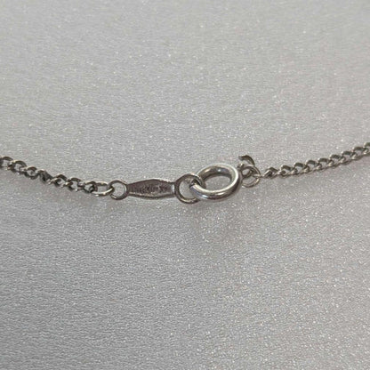 Mikimoto necklace with silver diamond-shaped pendant and glossy white pearl hanging on a 42cm silver chain