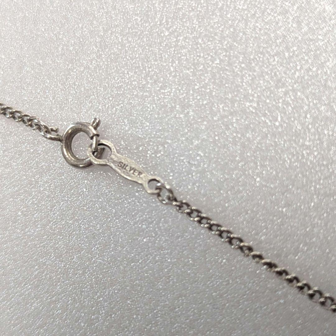 Mikimoto necklace with silver diamond-shaped pendant and glossy white pearl hanging on a 42cm silver chain