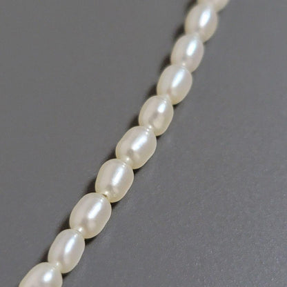 Suzunoya pearl necklace with small oval Akoya pearls and 925 silver clasp on white background