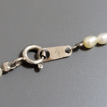 Suzunoya pearl necklace with small oval Akoya pearls and 925 silver clasp on white background