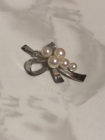 Silver ribbon-shaped pendant top adorned with five white pearls