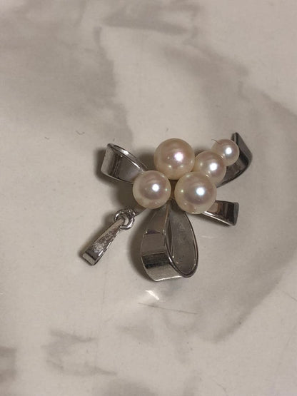 Silver ribbon-shaped pendant top adorned with five white pearls