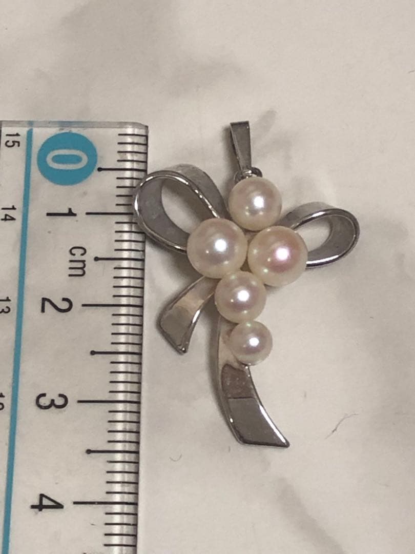 Silver ribbon-shaped pendant top adorned with five white pearls